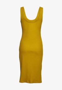 Robe midi côtelée en moutarde, avec un décolleté arrondi et une coupe près du corps, fabriquée en tissu extensible pour le confort.