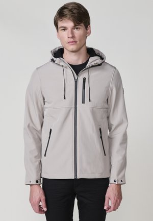 Chaqueta de cremallera en gris claro con capucha, que presenta cremalleras y acentos en negro, cordones ajustables elásticos y puños con broche. Material suave y liso.