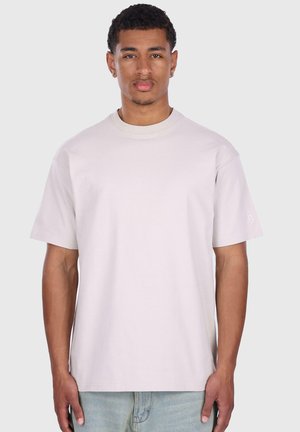 T-shirt léger gris clair à col ras du cou et à manches courtes, fabriqué en coton ; présente un logo discret sur la manche gauche et une coupe décontractée.