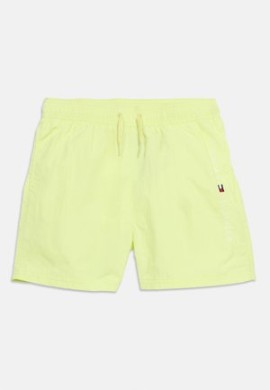 Lyse gule badeshorts med elastisk midjebånd og snor, med vertikal Tommy Hilfiger-logo og flagg på høyre ben.