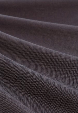 Artimo audinio uždarymas, turintis smulkų, tankiai austą paviršiaus tekstūrą ir minkštus raukšles, sudarančias įstrižas linijas per paviršių.