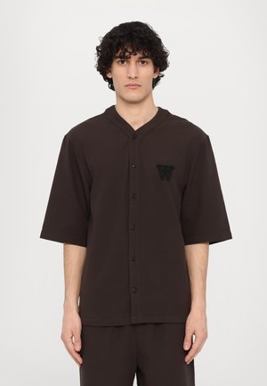 Brown short-sleeve button-up shirt with a v-neck, featuring a textured fabric and an embroidered letter "W" on the left chest.