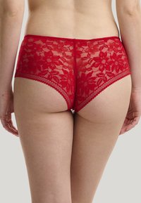 Rode kanten slipjes met bloemenpatroon, golvende randen en doorzichtige textuur, met een hoge uitsnijding en elastische tailleband.