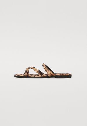 Sandales plates à imprimé léopard avec deux fines brides, dotées d'accents en métal doré et d'une semelle noire. Texture lisse et design minimaliste.