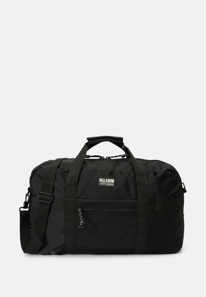 Mala de viagem preta feita de um tecido durável. Apresenta alças duplas, uma correia de ombro ajustável e um bolso frontal com fecho zip. Logótipo PALLADIUM exibido.