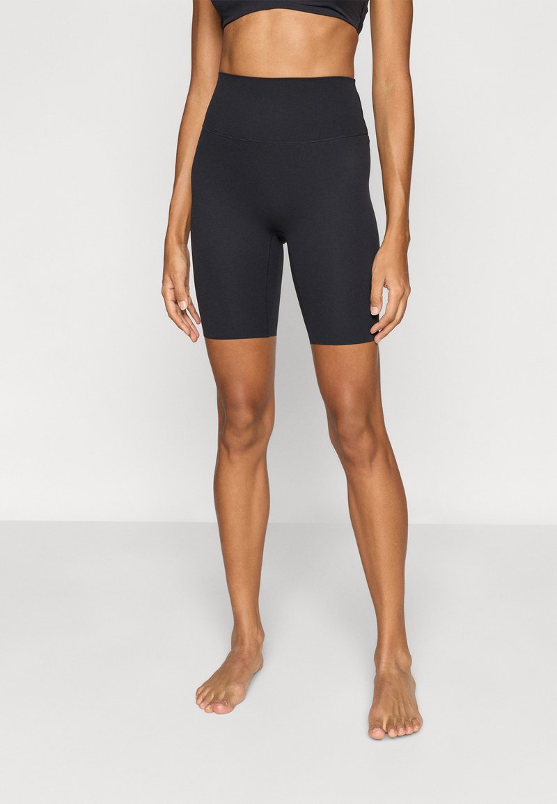 Μαύρο αθλητικό σορτς από ελαστικό ύφασμα, με ψηλή μέση και εφαρμοστή σχεδίαση που φτάνει μέχρι το μέσο του μηρού.