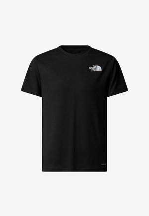 Jongen met afrokapel die een zwart The North Face t-shirt, lichtpaarse broek, zwarte sokken en grijze wandelschoenen draagt, kijkend naar de zijkant.