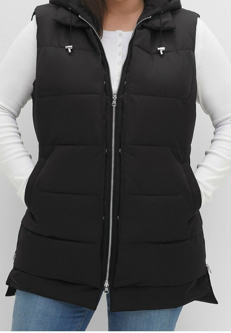 Schwarze Steppweste mit Kapuze, Reißverschluss vorne, Seitentaschen und Kordelzugakzenten. Glattes Material mit gestepptem Design. Leichtes Design.