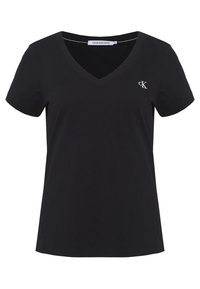 Černé bavlněné tričko s výstřihem do V, krátkými rukávy a malým bílým logem CK na levé straně hrudi. Jednoduchý a přiléhavý design.