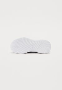 Suela de zapato atlético blanco con un patrón de agarre texturizado, que presenta ranuras diagonales y verticales, bordes redondeados y un acabado suave.
