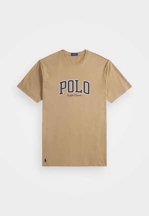 Beżowa koszulka z krótkim rękawem z napisem "POLO Ralph Lauren" w granatowym i białym na klatce piersiowej, małe logo gracza polo blisko dolnej krawędzi.