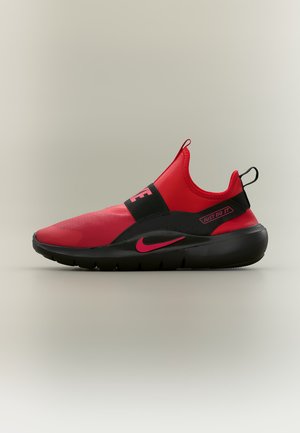 Baskets rouges et noires à enfiler, avec un logo Nike rose, une semelle noire et le texte « "Just Do It" » sur le côté, présentées sur un fond uni.