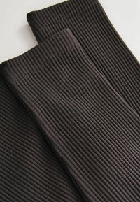 Black ribbed fabric, featuring vertical lines and a smooth texture, shown in overlapping layers, highlighting its stretch and softness.