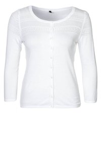 Vit cardigan med långa ärmar, rund halsringning och knappstängning. Har ett strukturerat stickat mönster vid axlarna och en slät kropp.