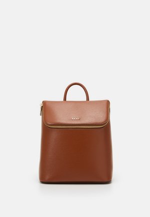 Sac à dos en cuir marron DKNY avec poignée supérieure, rabat avant avec fermeture éclair, et logo doré sur le devant, posé sur un fond clair uni.