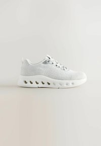 Chaussure de sport gris clair en mesh respirant avec une surface texturée, dotée d'une semelle blanche rembourrée avec des trous de ventilation.