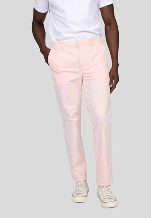 Chinos rose clair en tissu mélangé coton, présentant une coupe droite, des passants de ceinture et des poches avant. Associés à des baskets blanches.