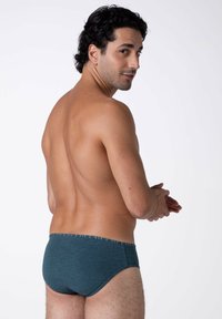 Costumi da bagno da uomo in verde scuro con una texture liscia e una vita elasticizzata a motivo, mostrati da dietro su uno sfondo neutro.