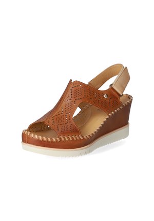 Brown leather wedge sandal featuring perforated design, open toe, adjustable strap, and braided detailing along the sole.