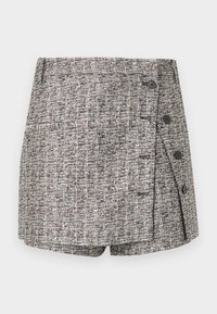 Pantalones cortos de tweed en una combinación de colores blanco y negro. Presentan un diseño cruzado con dos botones y un bolsillo lateral, tejido texturizado en toda la prenda.
