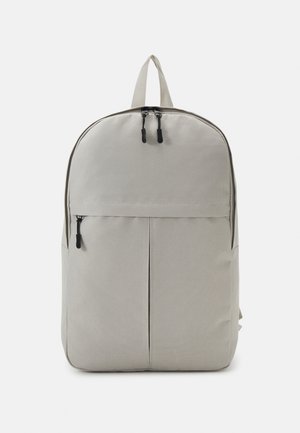 Grau Stoff Rucksack mit abgerundetem oberen Teil, vorderer Reißverschlusstasche, doppeltem Reißverschluss und zwei Seitentaschen. Texturierte Oberfläche, minimalistisches Design.