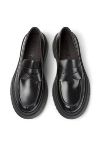 Pair of black leather loafers with chunky rubber soles, detailed stitching, and a strap across the top, shown from above on a white background.