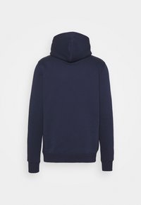 Un sweat à capuche bleu marine avec une texture douce, des manches longues et des poignets côtelés. Il présente un design sobre et sans ornement au dos.