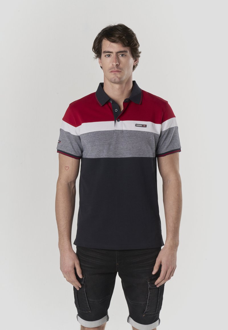 Polo à rayures horizontales rouges, blanches, grises et bleu marine, en coton, avec un col boutonné et un petit logo sur la poitrine.