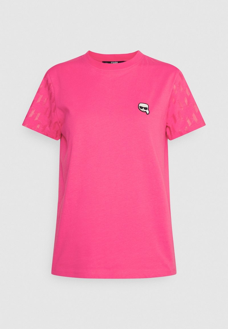 Fuchsiová růžová trička s krátkým rukávem, s grafickým logem a texturovanými detaily na rukávech. Vyrobeno z měkké bavlny.