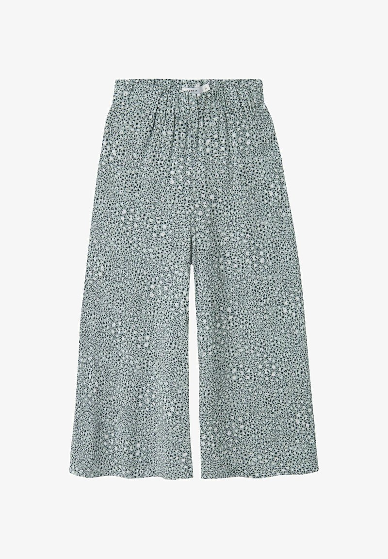 Lätta byxor med vida ben och elastiskt midjeband, med ett spritt mönster i grönt och svart på en vit bakgrund.