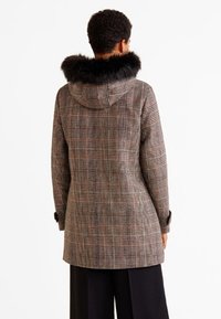 Abrigo de cuadros con capucha de piel sintética, con tonos marrón, naranja y gris. Corte recto, de longitud media, con detalles de botones en las mangas.