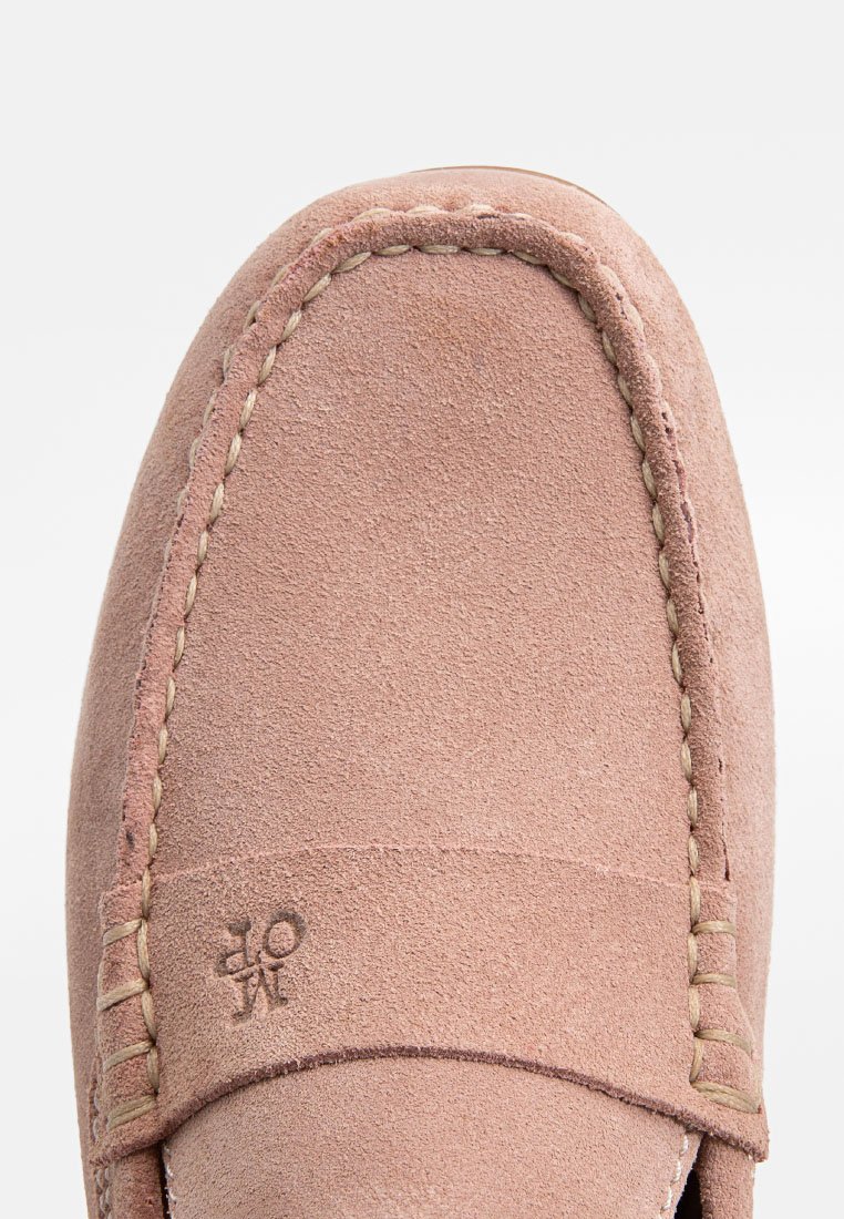 Jasnoróżowe zamszowe mokasyny o gładkiej fakturze, z ozdobnym przeszyciem i wytłoczonym logo na cholewce. Okrągły kształt noska.