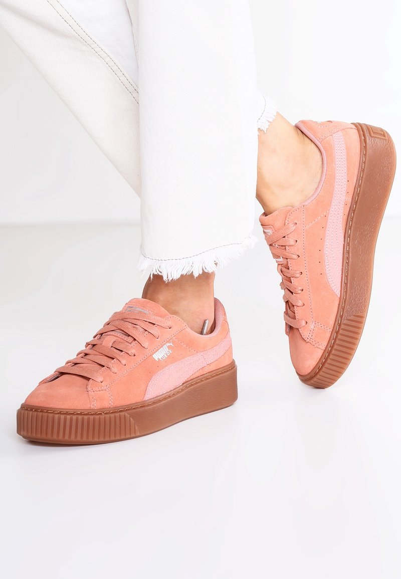 Baskets en suède rose avec une finition texturée, dotées d'une semelle plateforme, de lacets en ruban et d'un design à rayures roses contrastantes.