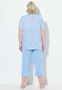 Conjunto de pijama azul claro que incluye una camiseta de manga corta con un estampado floral y pantalones cortos; material de algodón, ajuste casual.