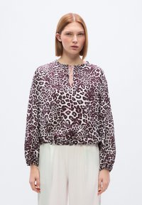 Μπλούζα με λεοπάρ μοτίβο σε απαλό ύφασμα, με στρογγυλή λαιμόκοψη και λεπτομέρεια δέσιμου, ελαστικό τελείωμα και μακριά μανίκια με μανσέτες που μαζεύουν.