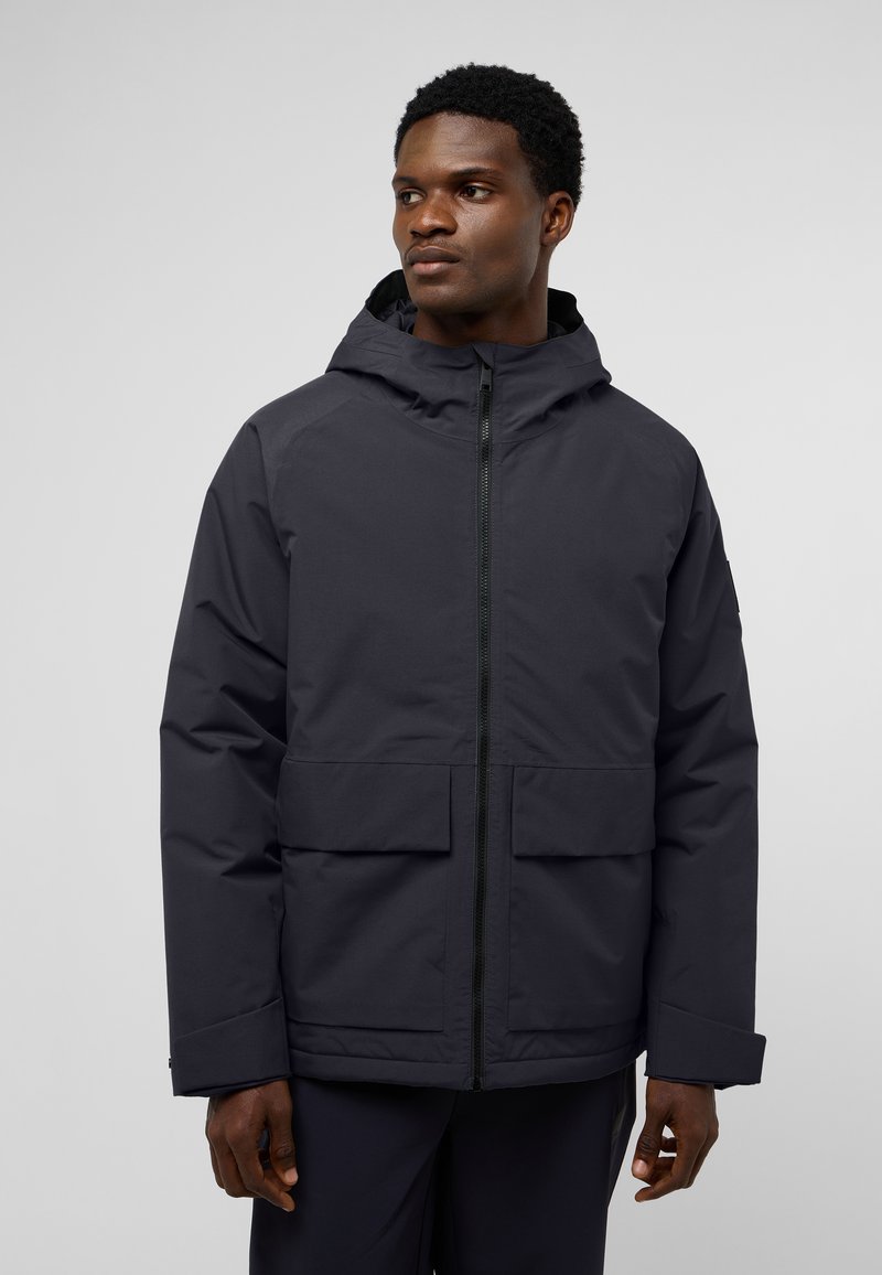 Veste imperméable gris foncé avec capuche, fermeture éclair frontale et deux grandes poches externes. Caractéristiques : coupe décontractée avec poignets ajustables.