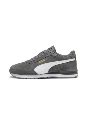 Sneaker Puma grigio con striscia bianca laterale, logo Puma dorato, design con lacci e suola imbottita, mostrato in profilo su uno sfondo bianco.