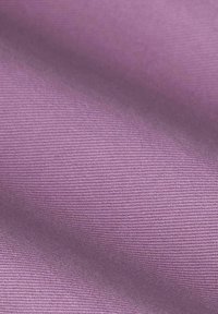 Tissu violet doux avec une texture côtelée fine et des plis légers créant des variations de lumière et d'ombre.