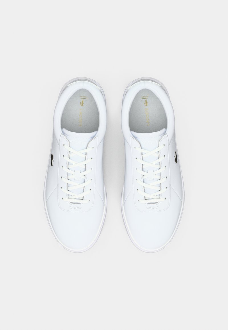 White lace-up sneakers featuring a smooth leather upper, rounded toe, and a small black logo on the side. Simple, minimalist design.