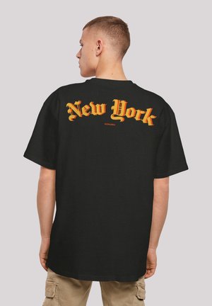 Black cotton t-shirt featuring bold orange and yellow "New York" text on the back. Short sleeves and a relaxed fit.
