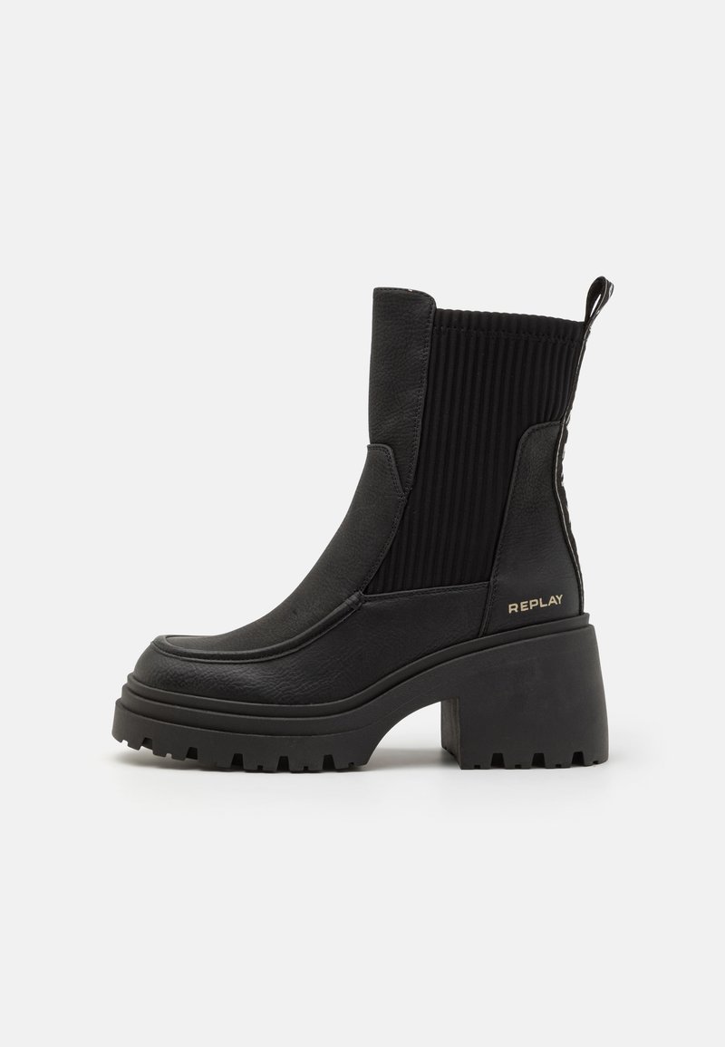 Bottine noire à talon avec semelle épaisse, panneau latéral élastique côtelé, languette à l'arrière et logo "REPLAY" sur le contrefort du talon.