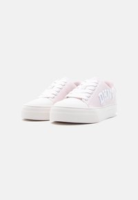 Ροζ ανοιχτού χρώματος αθλητικά παπούτσια με χαμηλή πλατφόρμα, λευκά κορδόνια και λογότυπο DKNY στο πλάι, εμφανιζόμενα από τη μπροστινή αριστερή γωνία σε λευκό φόντο.