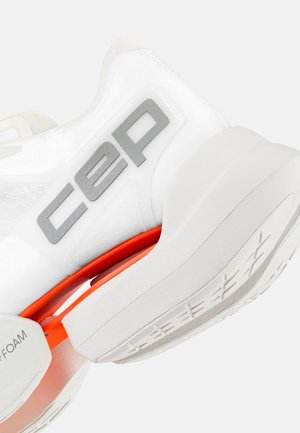 Close-up of white athletic shoe with gray "cep" logo, orange midsole support, and white sole with textured grip pattern.