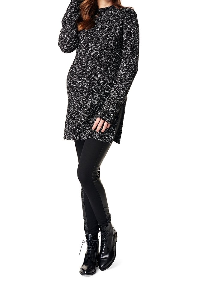 Tunique en tricot noir et blanc à manches longues, dotée de fentes latérales, accompagnée de leggings noirs et de bottes à lacets noires brillantes.