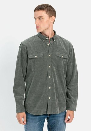 Long-sleeve button-up shirt in dark green fabric with a textured finish, featuring two chest pockets and a classic collar design.