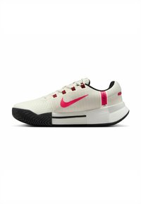 Scarpa sportiva bianca con tomaia testurizzata, baffo Nike rosa, suola nera e accenti rossi. Presenta una intersuola imbottita per il supporto.