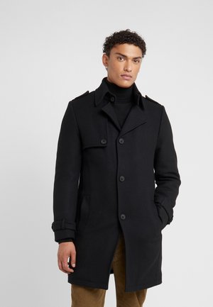 Black coat made of wool blend, featuring a notched collar, double-breasted buttons, side pockets, and adjustable cuffs.