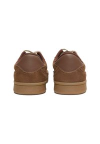 Sneaker in suede marrone con accenti in pelle, talloni arrotondati e suola in gomma di un marrone chiaro. Presentano una tomaia testurizzata e cuciture a contrasto.
