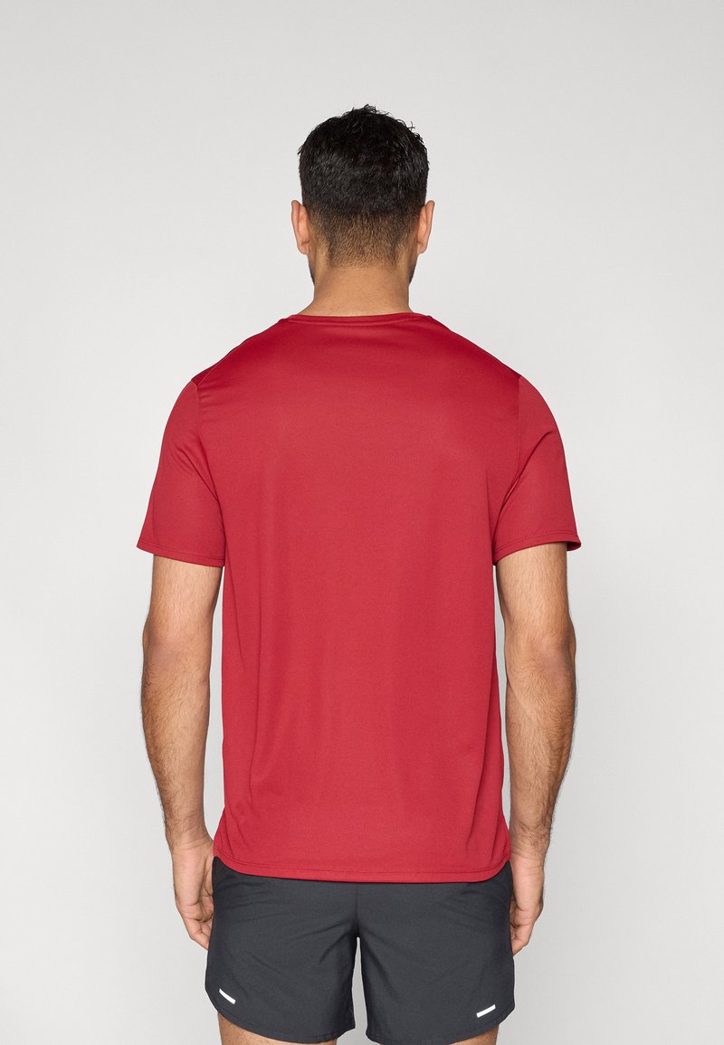 Rotes Sportshirt mit kurzen Ärmeln aus glattem, leichtem Stoff. Verfügt über einen einfachen Rundhalsausschnitt und eine lockere Passform. Schlichtes Design, keine sichtbaren Muster.