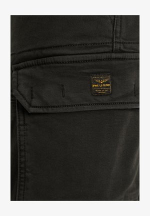 Pantaloni cargo neri con una texture liscia, dotati di un'apertura per la tasca e un'etichetta con testo giallo. I dettagli cuciti arricchiscono il design.